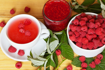 Summer still life with ripe berries, cup of а cool raspberry water and jars of homemade jam. Top view