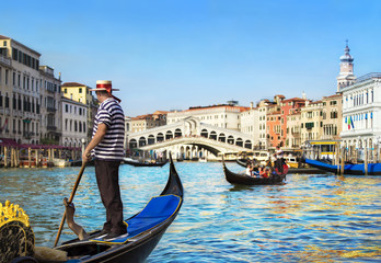 Fototapeta na wymiar Venice, Italy. Gondolier with rowing oar in his gondola on Grand Canal look at Rialto Bridge against other gondolas in sunny day