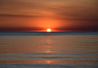 The Sun casts orange shades across an evening sky at Mindil Beach (Darwin, Northern Territory, Australia).