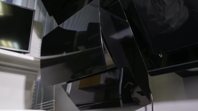 The man presses the buttons on the control panel with a modern extractor, ventilation