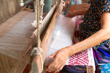 Fototapeta na wymiar The hands of old woman weaving, the ancient weaving method.