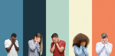 Group of people over vintage colors background with sad expression covering face with hands while...
