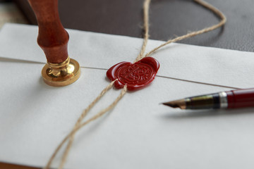 Old feather, envelope and sealing wax on wooden table