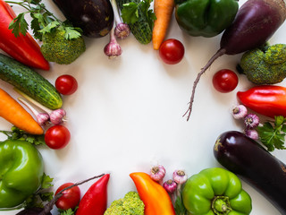 Fresh vegetables on a white background. Eggplant, beets, peppers, carrots, broccoli, cucumber, garlic, tomatoes.