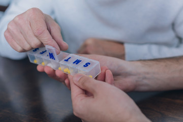 Wonderful medication. Aged man taking a small yellow effective pill from a small box