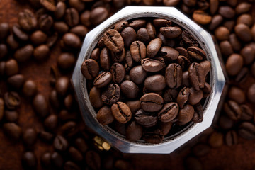 Photo closeup of coffee beans in Aluminium Espresso Coffee Maker. Rusty background. Copy space.