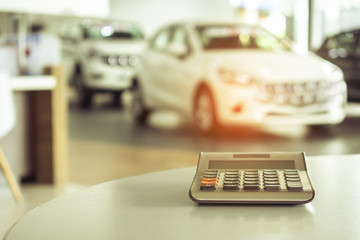 calculator for business finance on car showroom blurry background.for automotive automobile or...