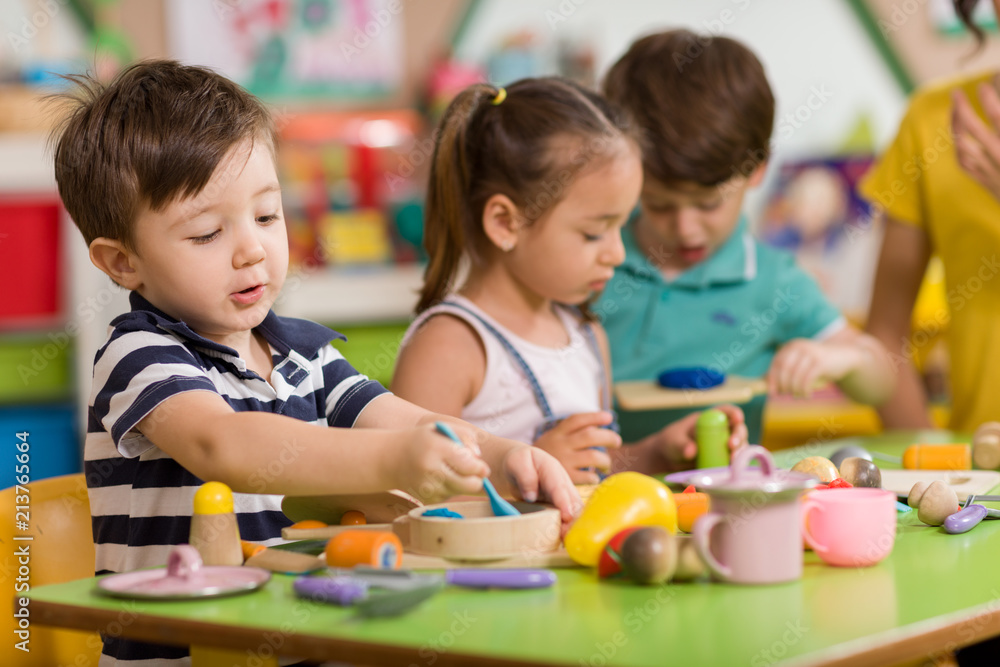 Poster childs are playing with play clay in classroom