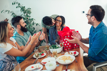 Group of multiethnic friends enjoying dinner birthday party