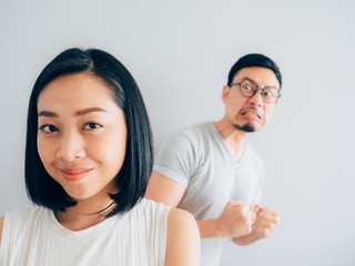 Happy Asian wife and angry loser husband.