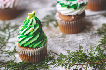 Decorated christmas cupcakes, on wooden background;