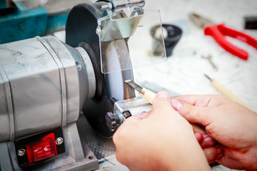 Sharpening the metal cutter on the grinding machine