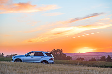 Moody sunset with cornfield and car