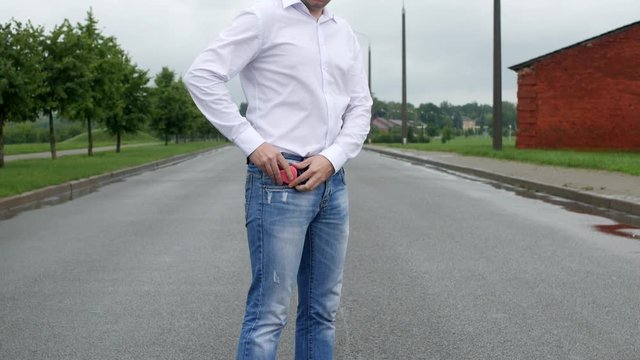 A man in the street takes out of his pocket a pink heart, homosexual