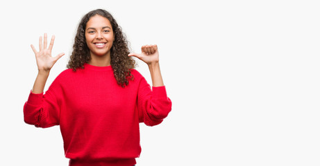 Young hispanic woman wearing red sweater showing and pointing up with fingers number six while smiling confident and happy.
