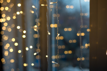 Electric Christmas garland on the window. A little light on the background of lights