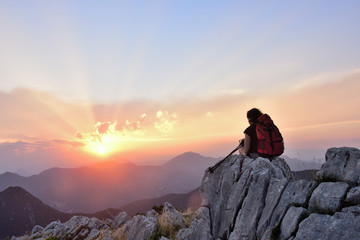 .female hiker resting and watching the sunset