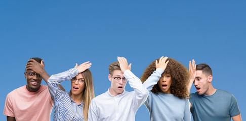 Composition of group of friends over blue blackground surprised with hand on head for mistake,...