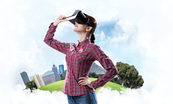 Girl in checked shirt wearing VR glasses experiencing another re