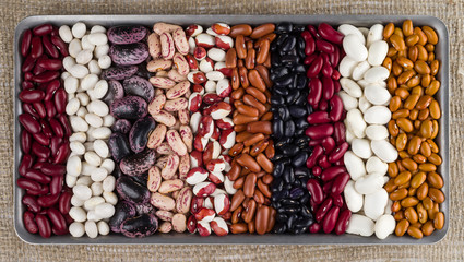 Different varieties of kidney beans against the background of the rough texture of burlap.