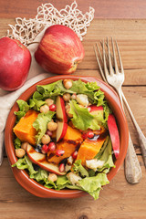 Fall salad with apple ,pumpkin and melogran on rustik background.
