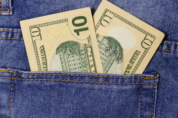Ten dollars banknote in the pocket of blue jeans