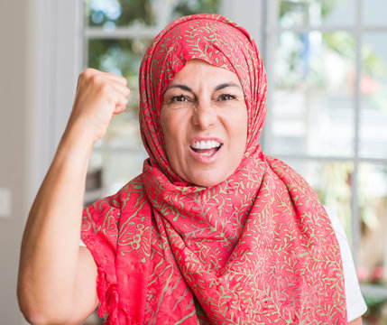 Middle aged muslim woman wearing hijab annoyed and frustrated shouting with anger, crazy and yelling with raised hand, anger concept
