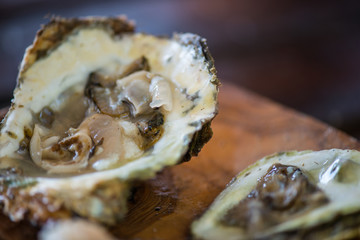 Oysters with lemon on wooden plate.