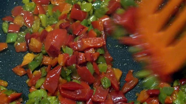 4k, Chef cooking red and green peppers in a frying pan. Roasting stewpan with tasty and healthy vegetables. Different color organic pepper sliced. Delicious nutritious organic dietary -Dan