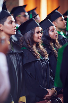 grroup of happy graduate students in gowns on graduation ceremony