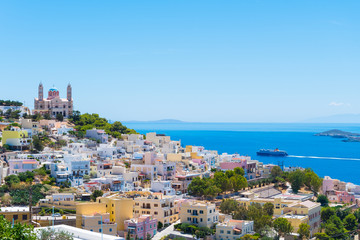 Fototapeta premium Panoramic view of Ermoupoli city of Syros Island in Cyclades, Greece. Top view of the colorful houses, the port and the Orthodox Anastaseos church