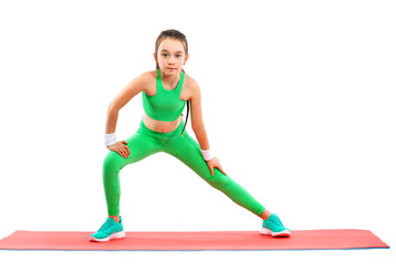 Kid girl doing fitness or yoga exercises isolated on white background. Sport concept.