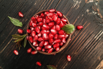 pomegranate seeds on wooden background.