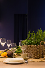 Empty wine glasses and basket with greenery on the blue background