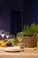 Empty wine glasses and basket with greenery on the blue background