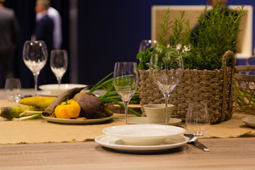 Empty wine glasses and basket with greenery on the blue background