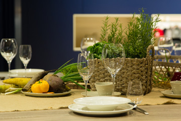 Empty wine glasses and basket with greenery on the blue background