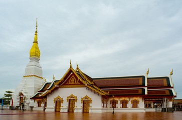 Naklejka premium Phra That Choeng Chum temple Sakon Nakhon province Thailand / Phra That Choeng Chum pagoda and sanctuary in Phra That Choeng Chum temple,There are blue skies and fluffy white clouds in the background.
