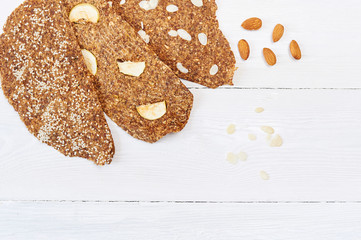 Bread with flaxseeds and almonds on a white wooden background. Useful dietary raw bread vegan breakfast without yeast