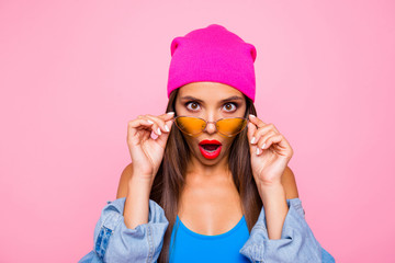 WOW! Close up portrait of shocked girl face looks over the glasses directly at the camera isolated...
