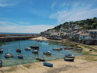 England, Cornwall, Mousehole Harbour at low tide - 213783037