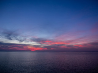 Red and purple sky above sea