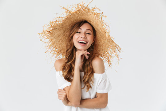 Portrait closeup of happy young woman 20s wearing big straw hat posing on camera with lovely smile, isolated over white background