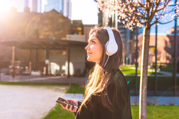 portrait young woman outdoor in the city listening music headphones - music, relaxing, enjoyment...