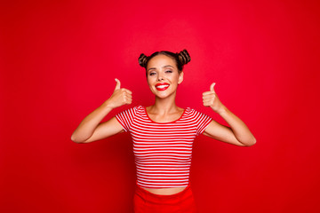 Young happy and cheerful woman showing thumb up by both hands isolated on red background