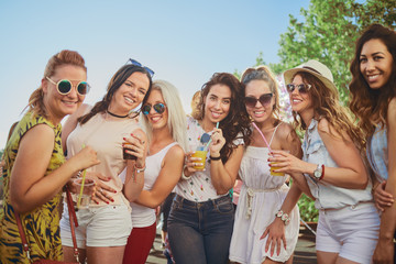 Group of female friends posing and having a good time at the outdoor party/music festival 