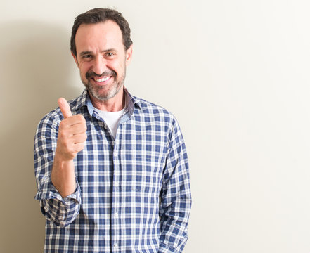 Senior man happy with big smile doing ok sign, thumb up with fingers, excellent sign