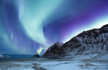Northen light above mountains and ocean. Beautiful natural landscape in the Norway