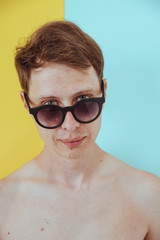 Portrait of man with sunglasses on solid colored background. Pastel palette. Fashion lifestyle