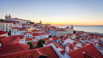 A view of Lisbon's rooftops at sunrise from the Miradouro das Portas do Sol - Lisbon, Portugal 